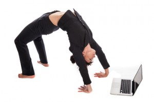西装女子在瑜伽姿势与笔记本电脑工作