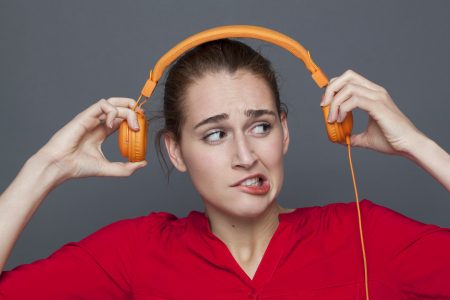woman looking oddly at headphones