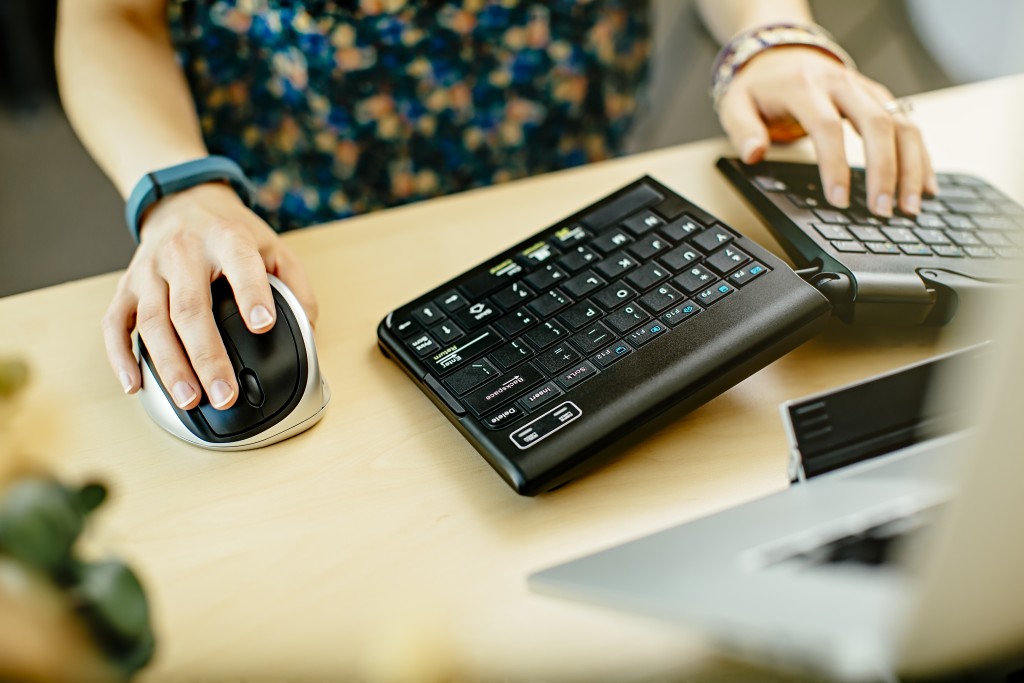 女人用键盘和鼠标在桌子上
